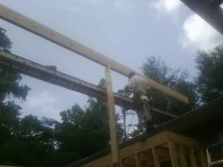 Carpenter setting a ridge beam over a new addition frame — Ice Dam Removal by Roofing Brothers in Cascade Locks