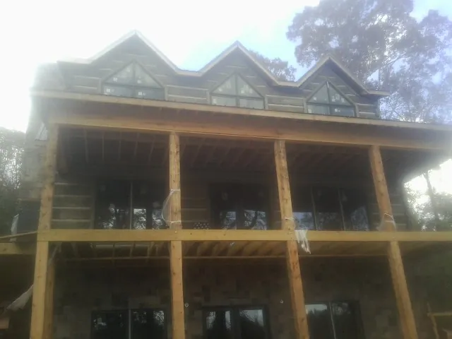 Dormers and porch framing on a large log home under construction — Roof Coating work by our crew in Cascade Locks