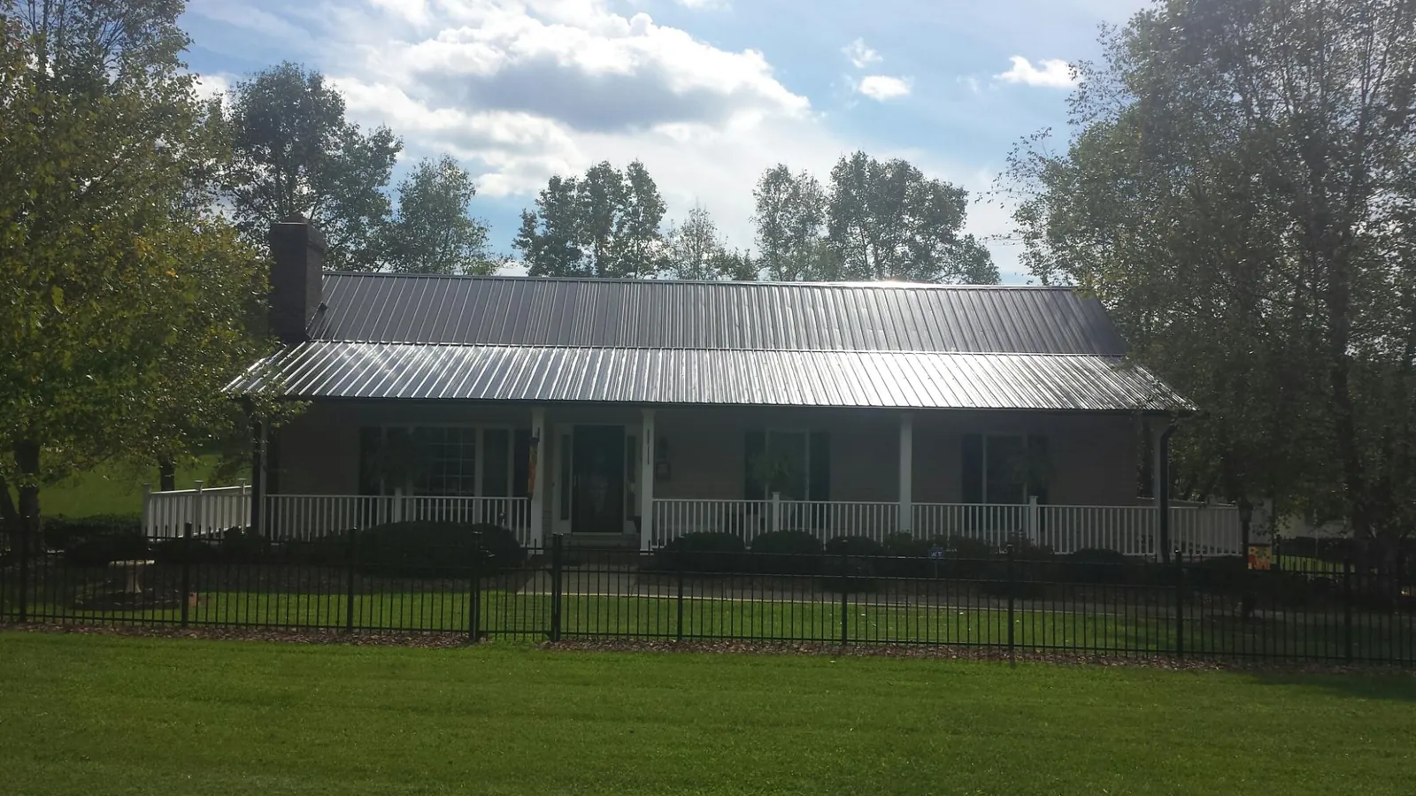 Gray metal roof on a brick ranch with a full width front porch — Gutter Guard Installation work by our crew in Cascade Locks